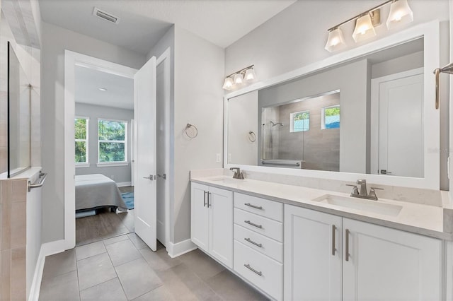 bathroom featuring tile patterned flooring, vanity, and tiled shower