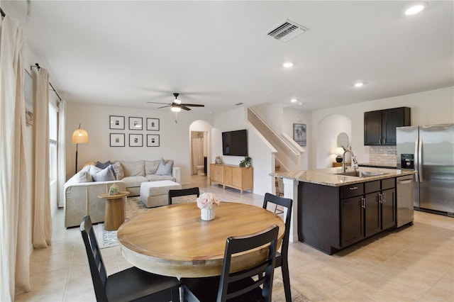 tiled dining space with sink and ceiling fan