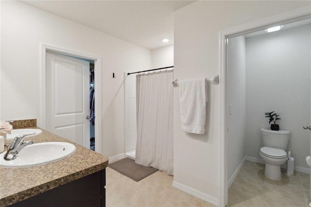 bathroom featuring vanity, tile patterned floors, toilet, and walk in shower