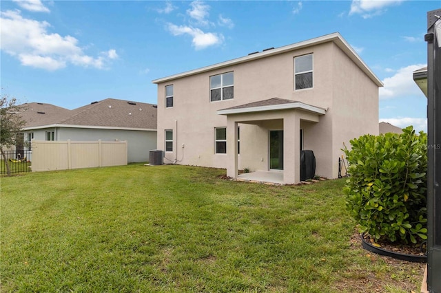 rear view of property with a patio, a lawn, and cooling unit