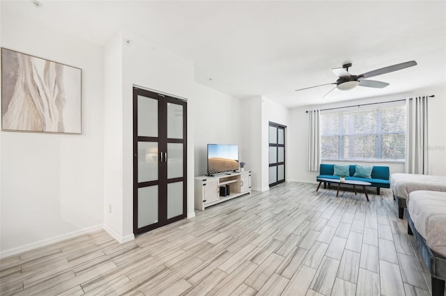 living room featuring light wood-type flooring and ceiling fan