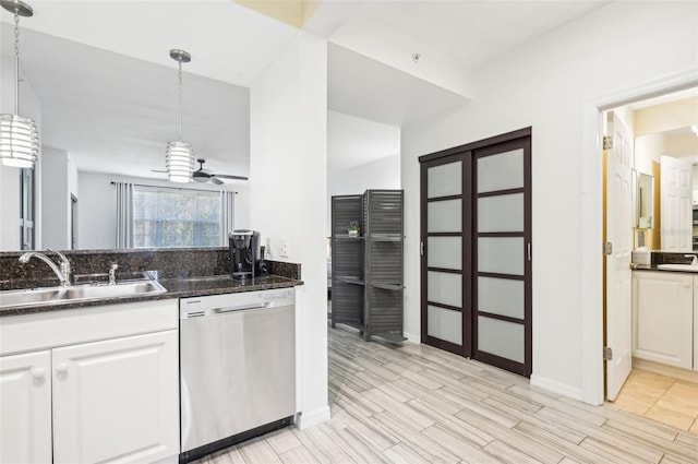 kitchen with stainless steel dishwasher, sink, white cabinets, and decorative light fixtures