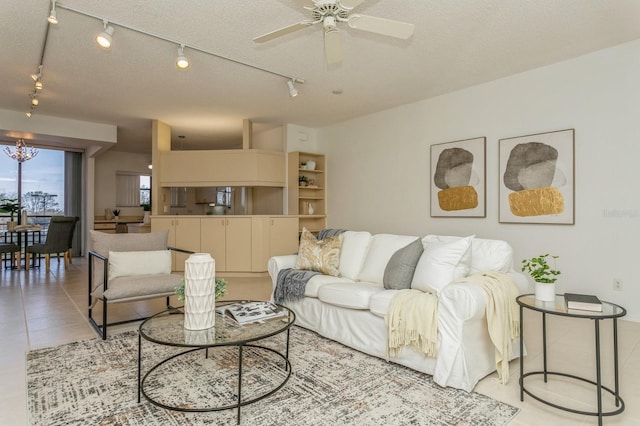 living room featuring a textured ceiling, track lighting, light tile patterned floors, and ceiling fan