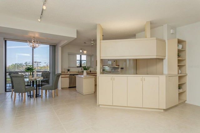 kitchen featuring light tile patterned flooring, ceiling fan with notable chandelier, a kitchen island, a textured ceiling, and stainless steel appliances