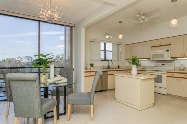 kitchen featuring a kitchen island, decorative light fixtures, white appliances, and plenty of natural light