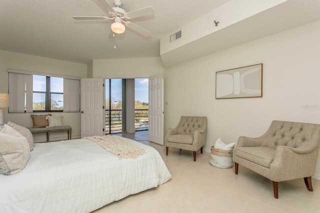 tiled bedroom featuring a textured ceiling, access to exterior, and ceiling fan