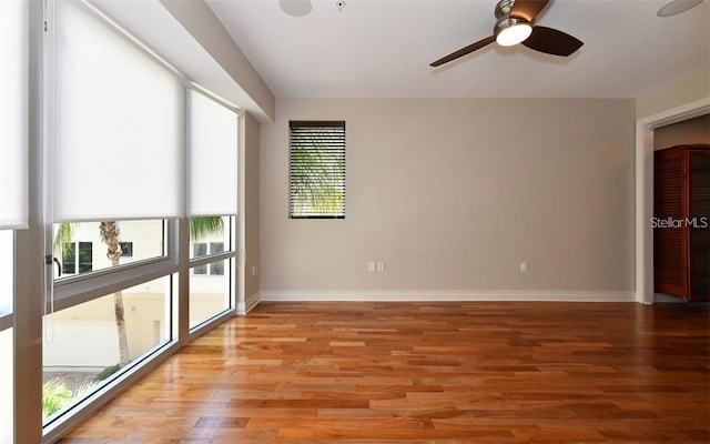 unfurnished room featuring baseboards, light wood finished floors, and ceiling fan