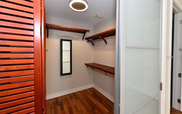 walk in closet with dark wood-style floors and visible vents