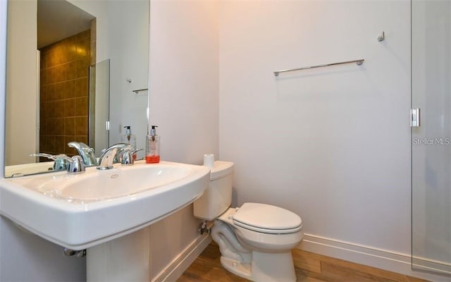 bathroom featuring baseboards, toilet, and wood finished floors