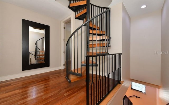 stairway with recessed lighting, baseboards, and wood finished floors