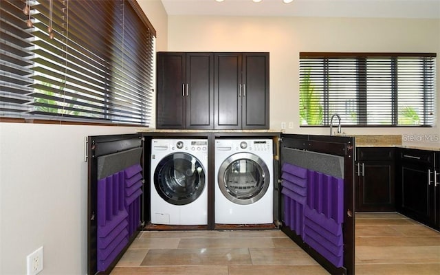 laundry area with cabinet space, separate washer and dryer, recessed lighting, and light wood-style floors