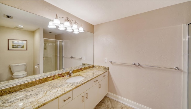 bathroom with vanity, toilet, and a shower with door