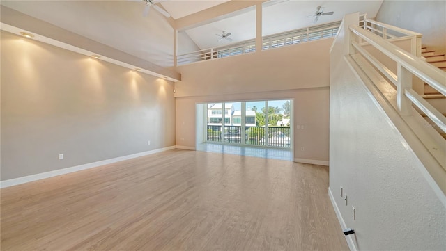 unfurnished living room featuring beamed ceiling, wood-type flooring, high vaulted ceiling, and ceiling fan