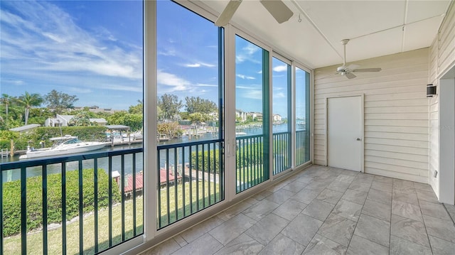 unfurnished sunroom featuring a water view and ceiling fan