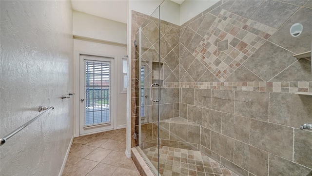 bathroom with a shower with door and tile patterned flooring