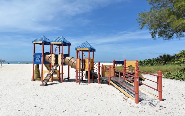 view of jungle gym featuring a water view and a view of the beach