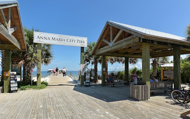 view of home's community with a gazebo, a water view, and a beach view