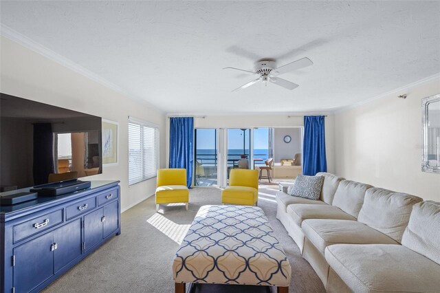 living room with a water view, ceiling fan, crown molding, and light colored carpet