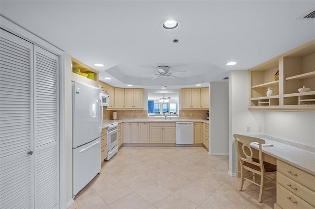 kitchen featuring tasteful backsplash, white appliances, ceiling fan, light brown cabinets, and built in desk