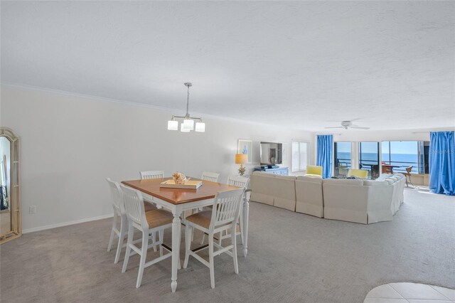 dining room with ceiling fan with notable chandelier, crown molding, and light carpet