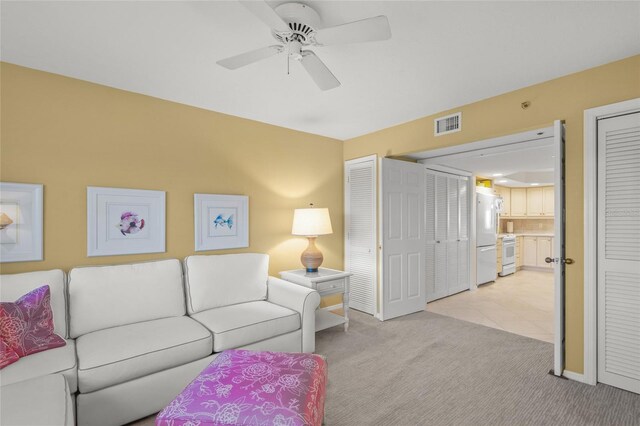 carpeted living room with ceiling fan