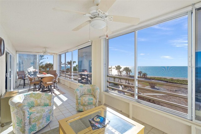 sunroom featuring a water view and ceiling fan