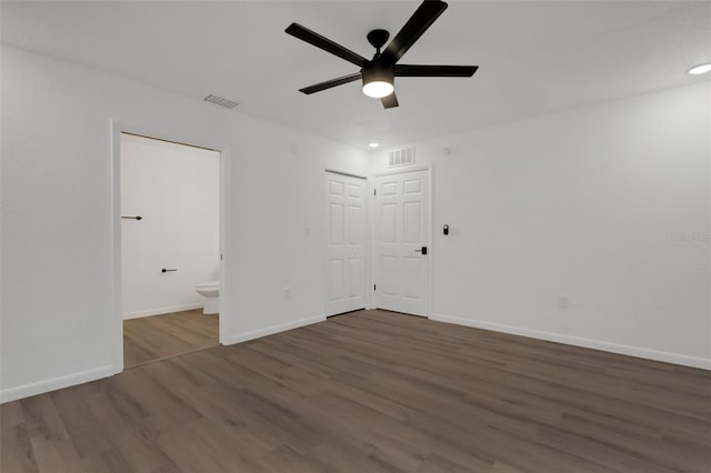 spare room featuring dark wood-type flooring and ceiling fan