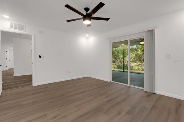 spare room with dark wood-type flooring and ceiling fan