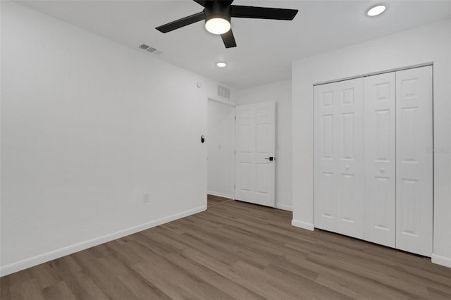 unfurnished bedroom featuring a closet, ceiling fan, and wood-type flooring