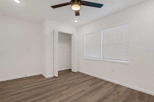 unfurnished bedroom with a closet, hardwood / wood-style flooring, and ceiling fan