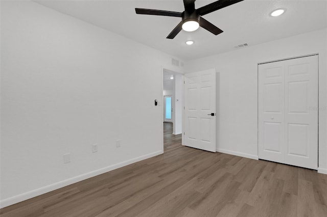 unfurnished bedroom with light hardwood / wood-style flooring, a closet, and ceiling fan