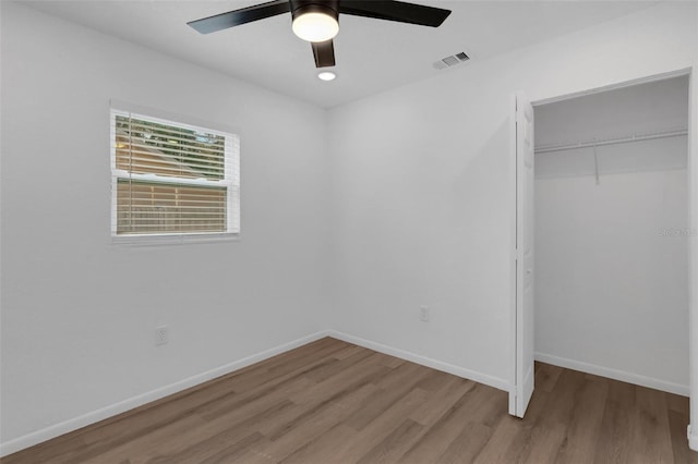 unfurnished bedroom featuring light hardwood / wood-style floors, a closet, and ceiling fan