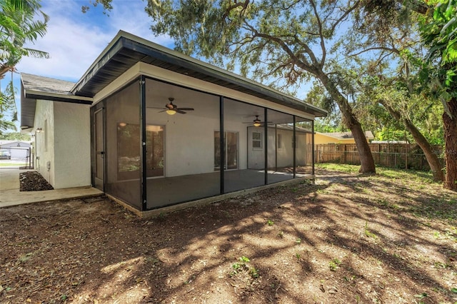 rear view of house featuring a sunroom and ceiling fan