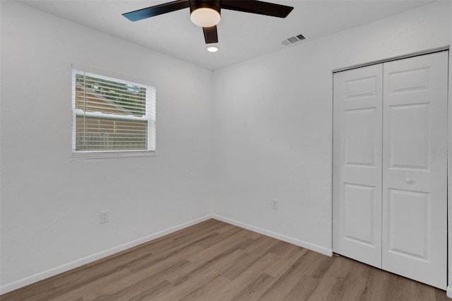 unfurnished bedroom featuring light hardwood / wood-style floors, a closet, and ceiling fan