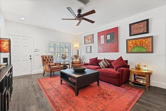 living room with ceiling fan, a textured ceiling, and dark hardwood / wood-style flooring