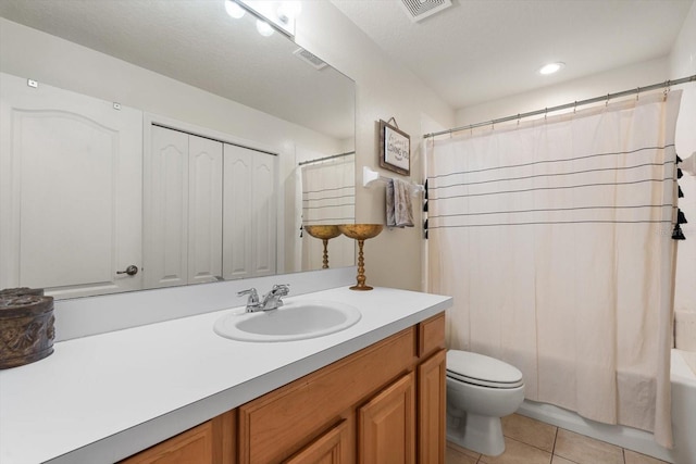 full bathroom with shower / tub combo, a textured ceiling, toilet, vanity, and tile patterned floors