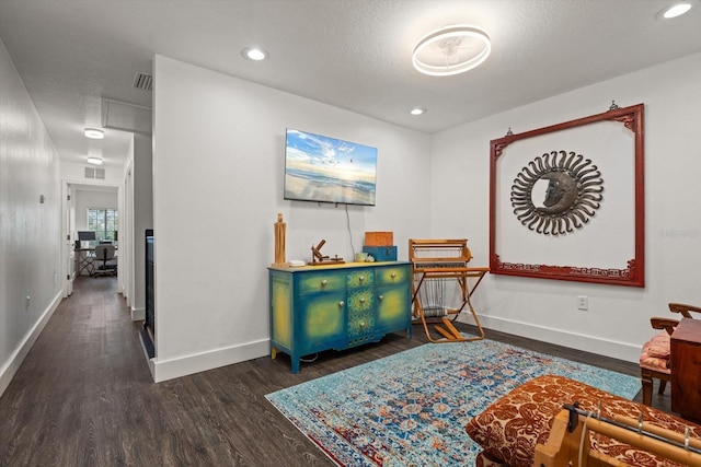 interior space with a textured ceiling and dark hardwood / wood-style floors