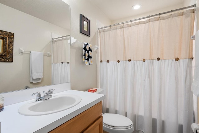 bathroom featuring toilet, walk in shower, and vanity