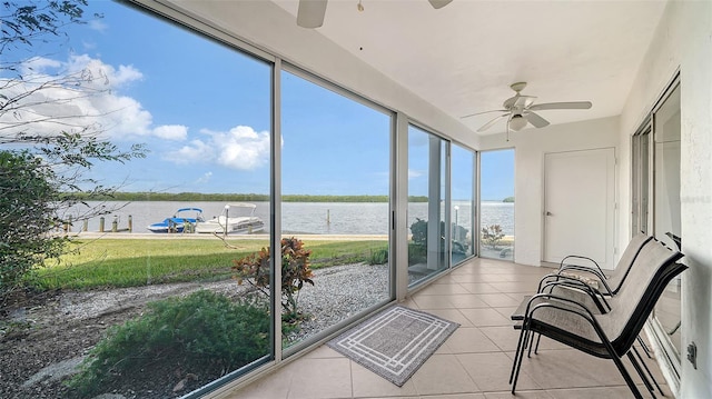 sunroom / solarium featuring a water view, ceiling fan, and plenty of natural light