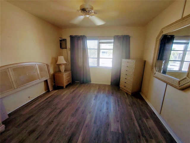 unfurnished bedroom featuring dark wood-type flooring and ceiling fan