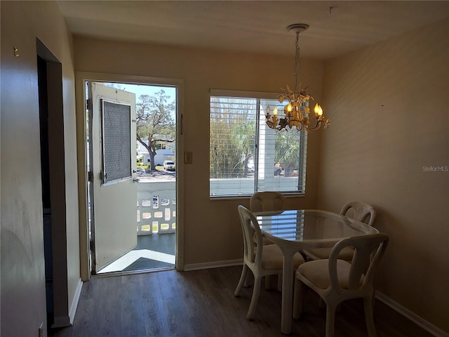 dining room with dark wood-type flooring and a notable chandelier