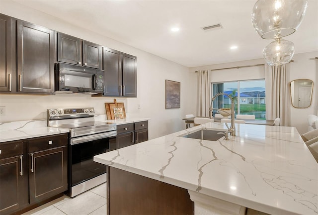 kitchen with dark brown cabinetry, sink, light stone countertops, and stainless steel range with electric stovetop