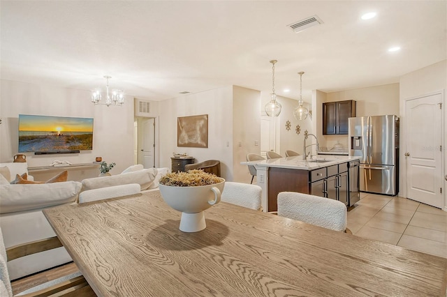 tiled dining area featuring sink and an inviting chandelier