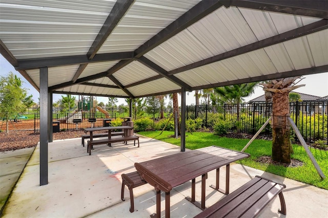 view of property's community featuring a yard, a patio area, and a playground