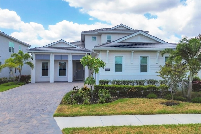 view of front facade featuring a tile roof and driveway