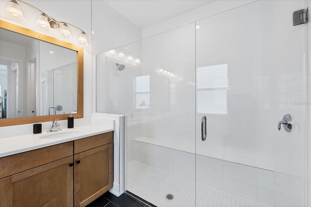 bathroom with a shower with door, vanity, and tile patterned flooring