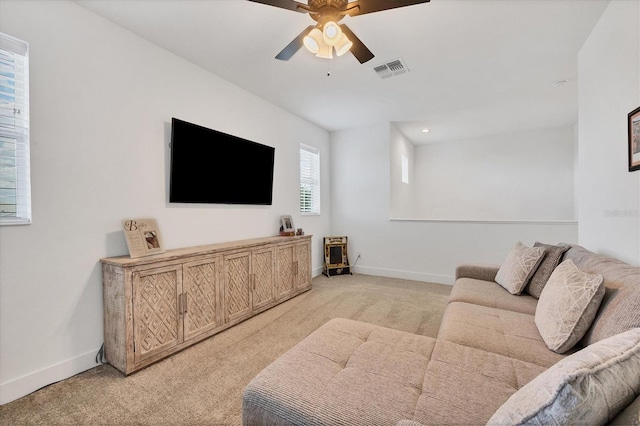 living room with ceiling fan and light colored carpet