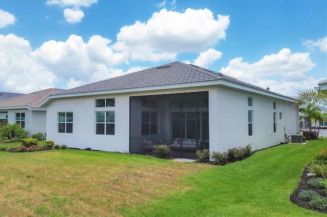 back of house with central AC, a lawn, and a sunroom