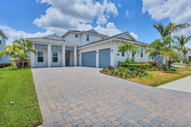 view of front of house featuring a garage, a front lawn, and decorative driveway