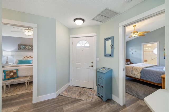 entrance foyer featuring ceiling fan, lofted ceiling, a textured ceiling, and dark hardwood / wood-style flooring